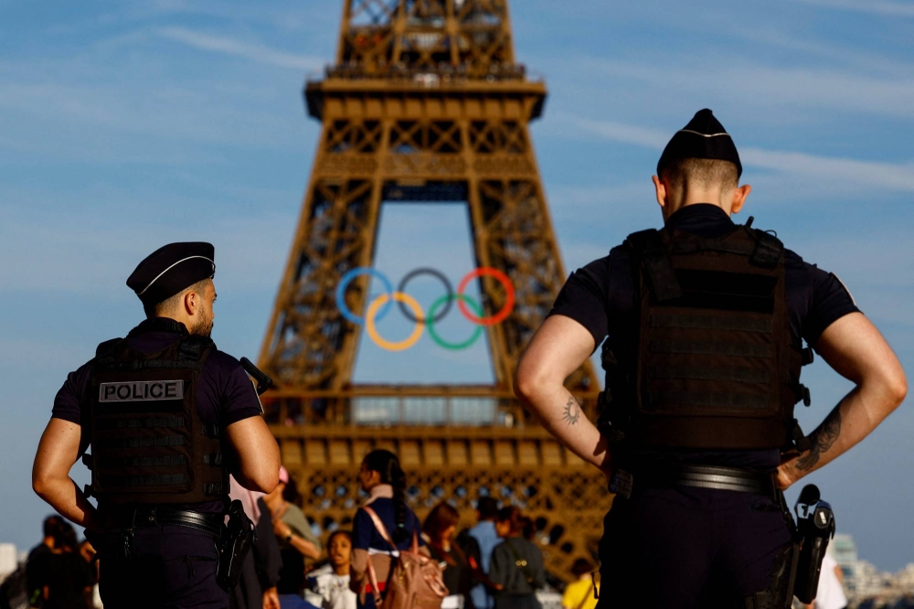 Police officers patrol on the Trocadero square in front of the Olympic rings displayed on the first floor of the Eiffel Tower ahead of the Paris 2024 Olympic games in Paris, France, June 7, 2024.