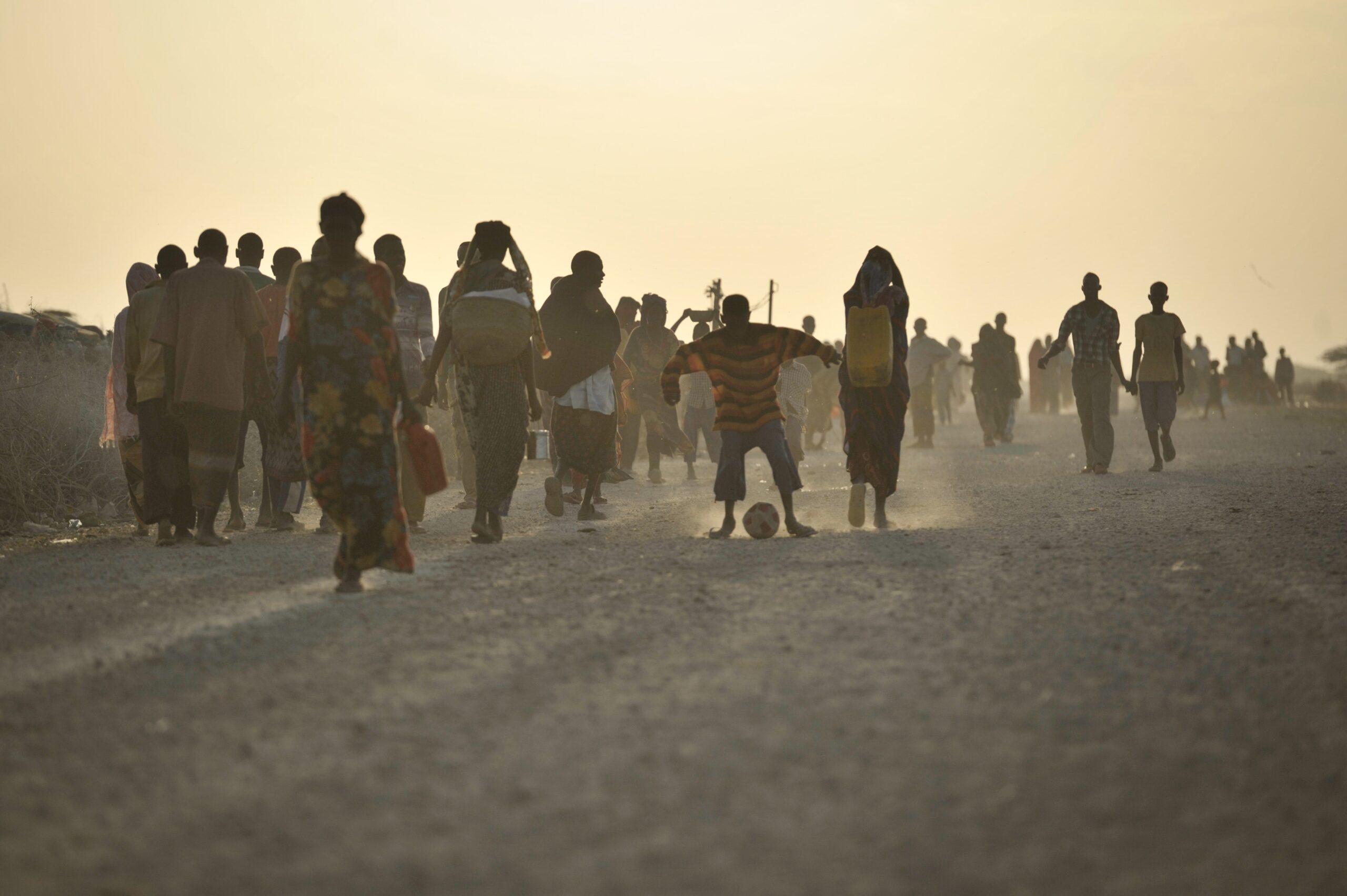 Image showing internally displaced persons, with a boy playing football.