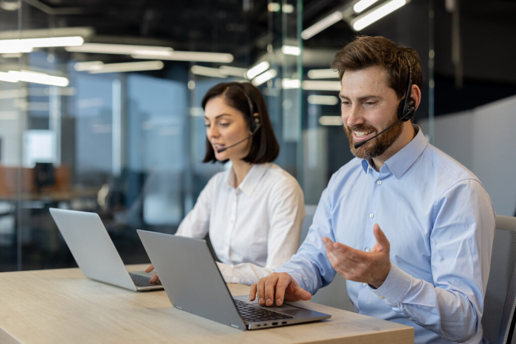 A man and a woman having a call on their computers about the repatriation of a body.
