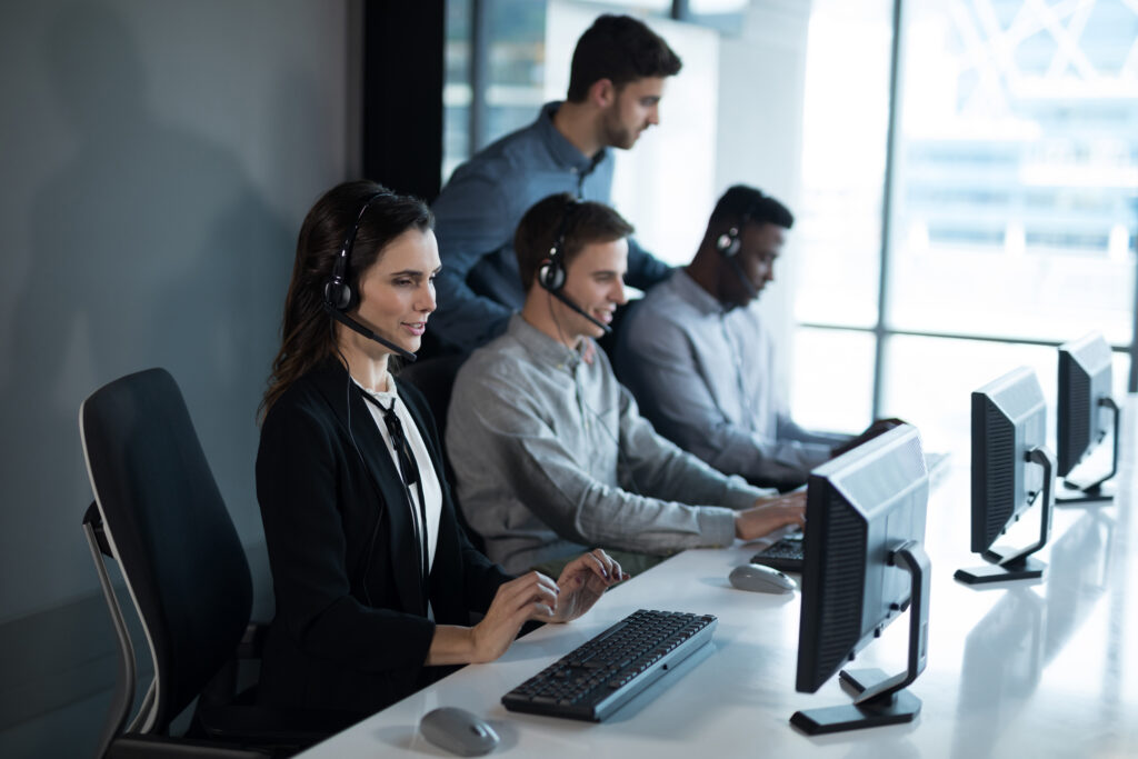 Corporate travel management team in headquarters monitoring the business trip through computer software.