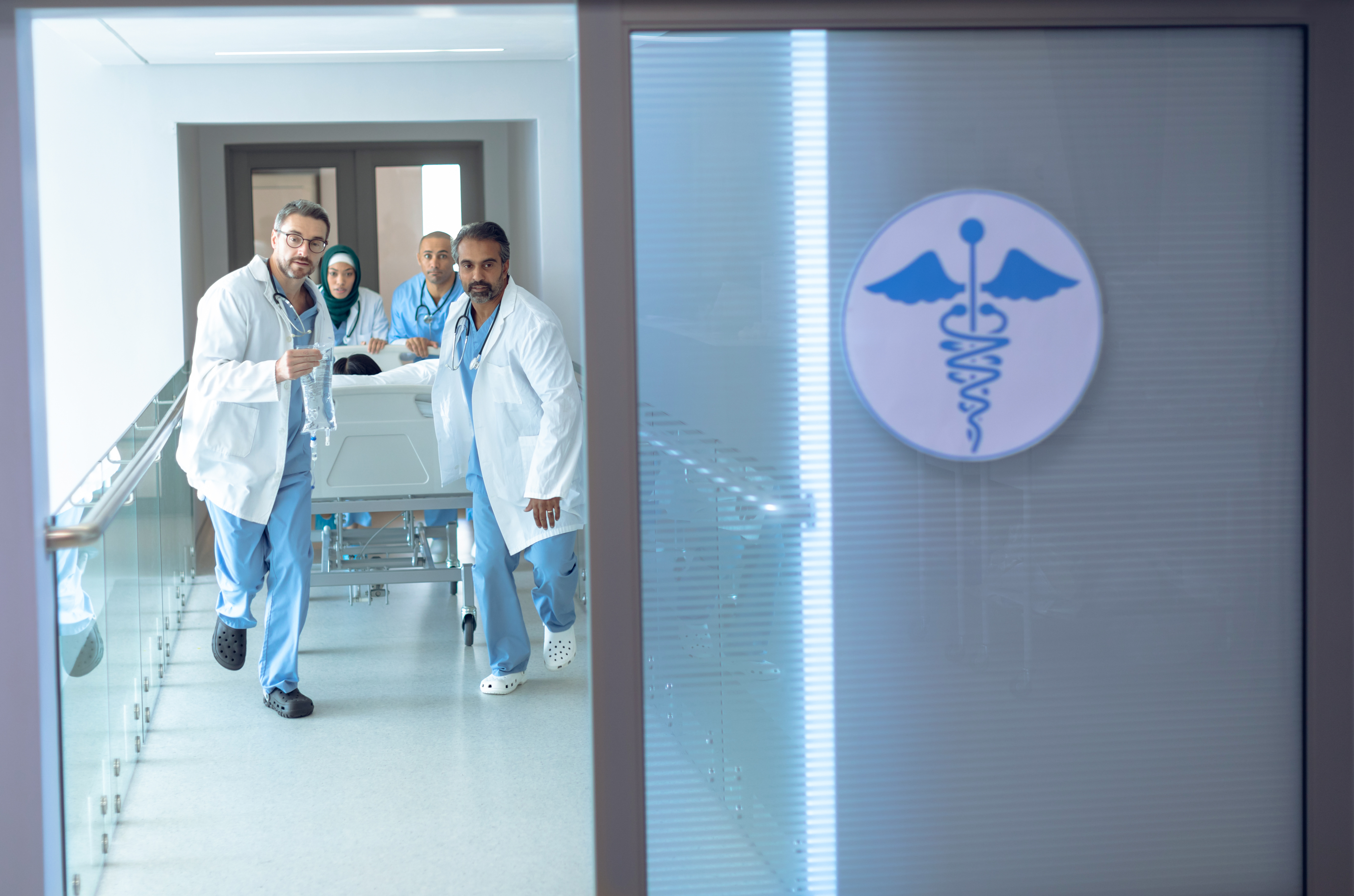 A team of doctors rushing a patient through a hospital corridor due to a medical emergency.