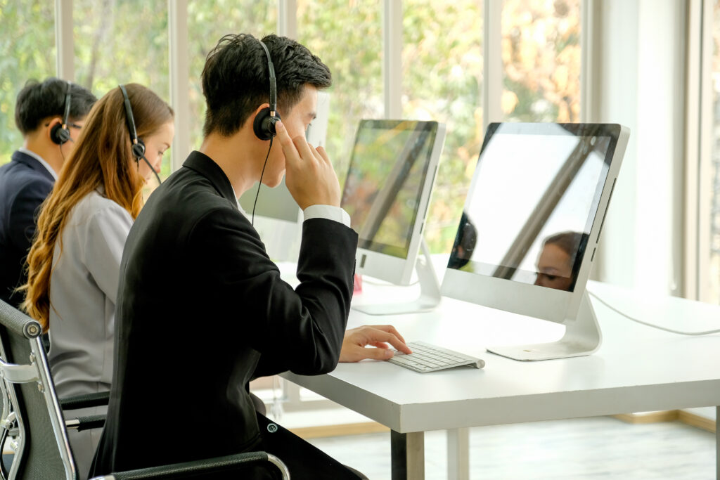 Business people working on computers with headsets coordinating the logistics of a medical emergency.