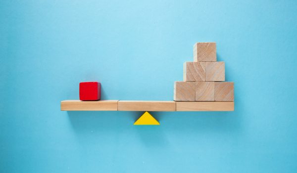 Balancing act: single red block outweighing stack of wooden cube