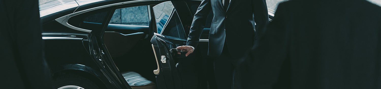 bodyguard in sunglasses opening car door to businessman - executive protection saudi arabia