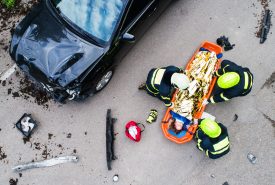 Paramedics treating a patient after a car accident.