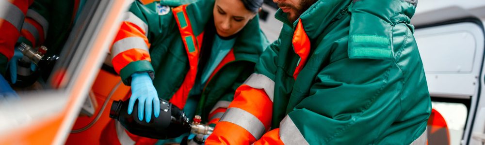 Two paramedics in an ambulance treating a patient during an emergency.