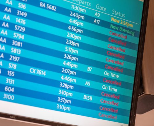Flight information board showing many cancelled flights due to increased evacuation demand.