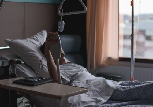 A patient lying in a hospital bed waiting for treatment.